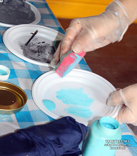 On prend de la peinture sur une éponge pour un pochoir